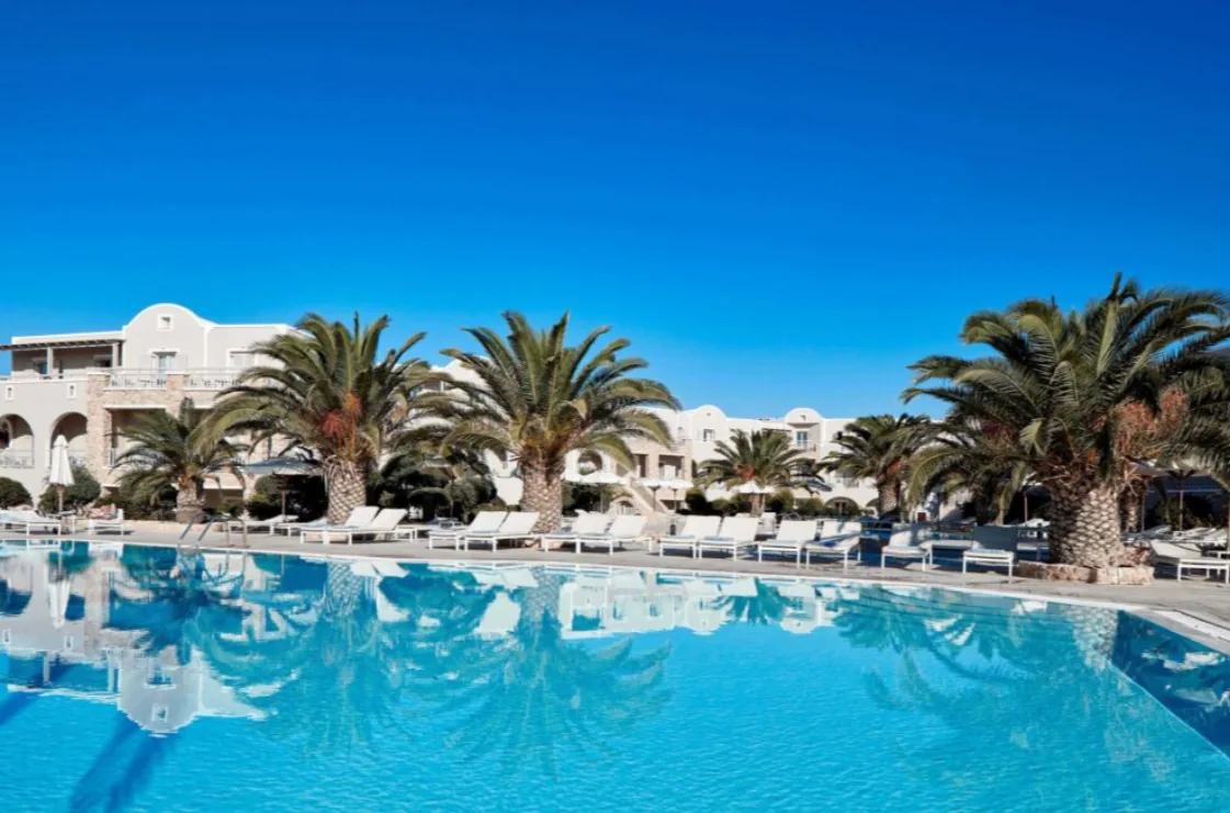 Bazén a palmy v areáli hotela na Santorini